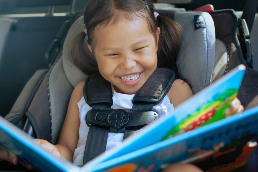 Child in car seat with a book