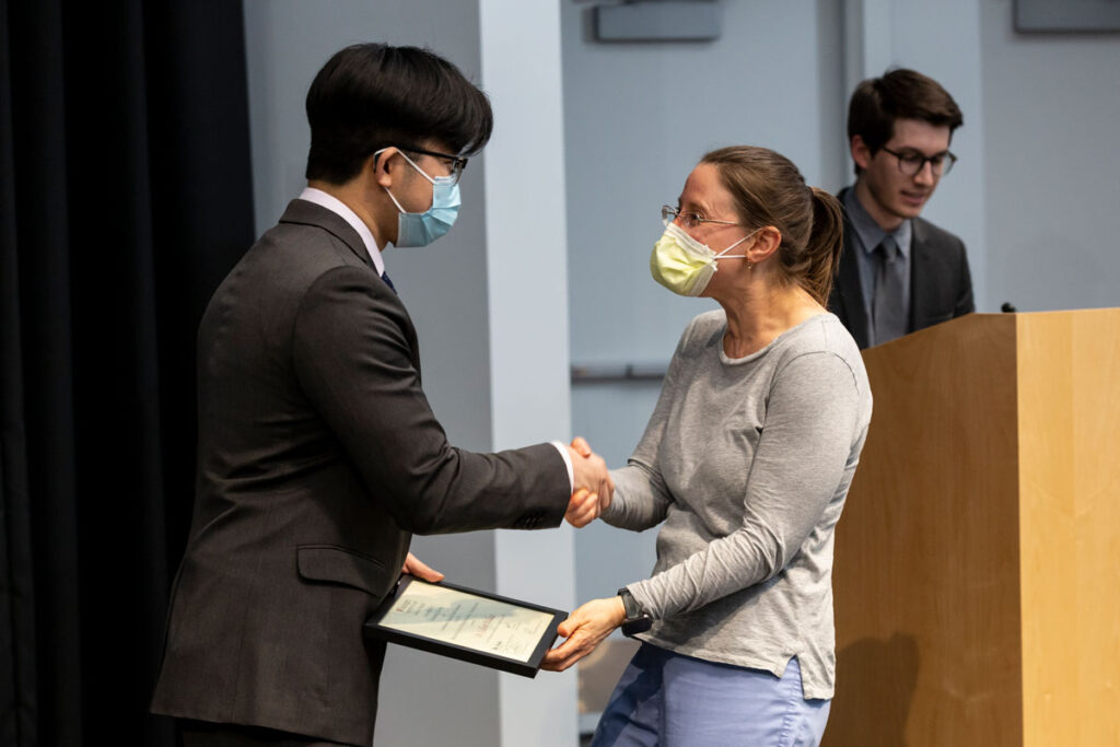 Medical student Yupeng Liu, representing the Class of 2024, presents a Distinguished Service Teaching Award to Colleen Wallace, MD, March 1 on the Medical Campus.
